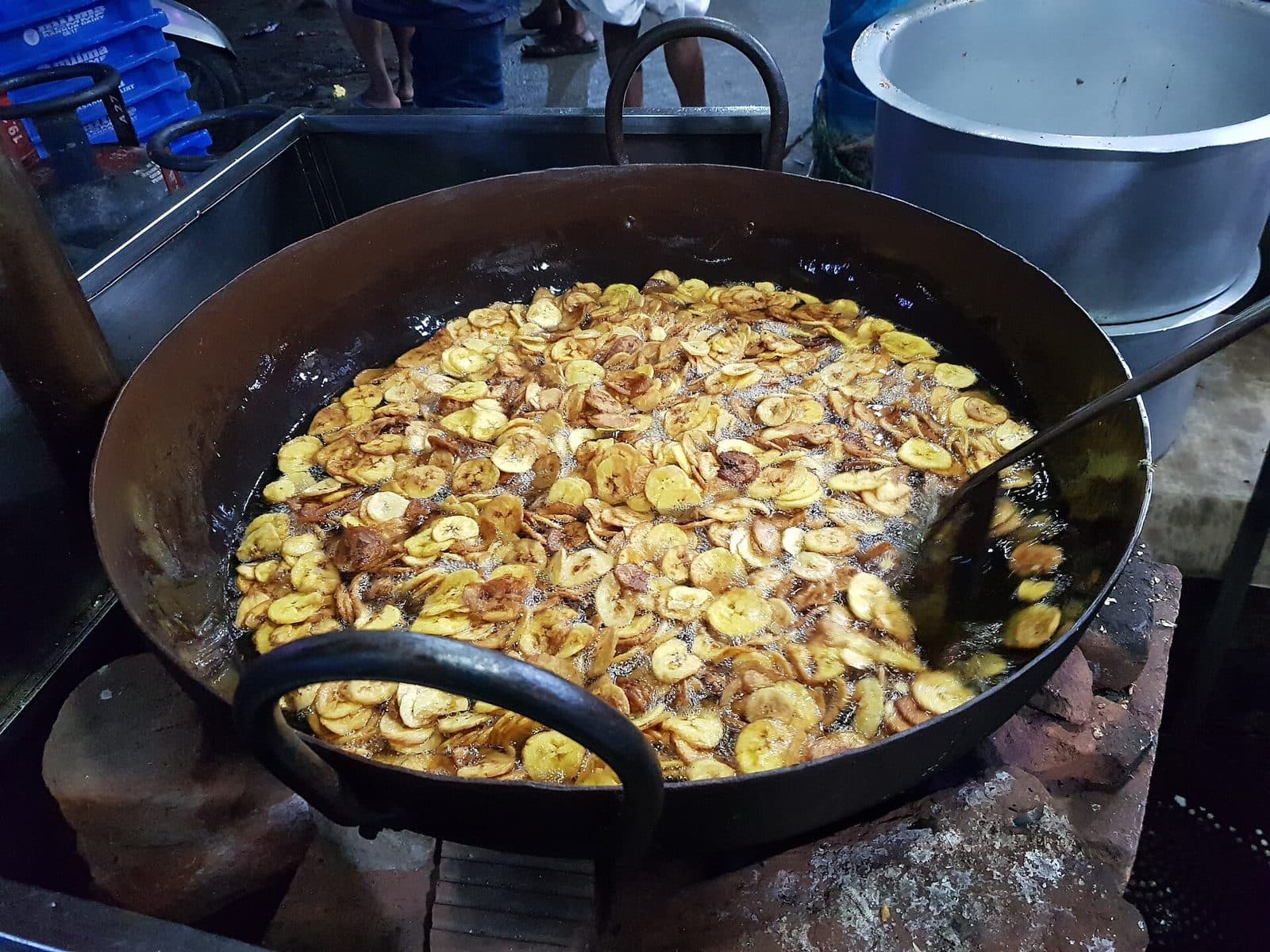 Banana chips frying in a large iron pan at a snack maker in Palakkad, Kerala