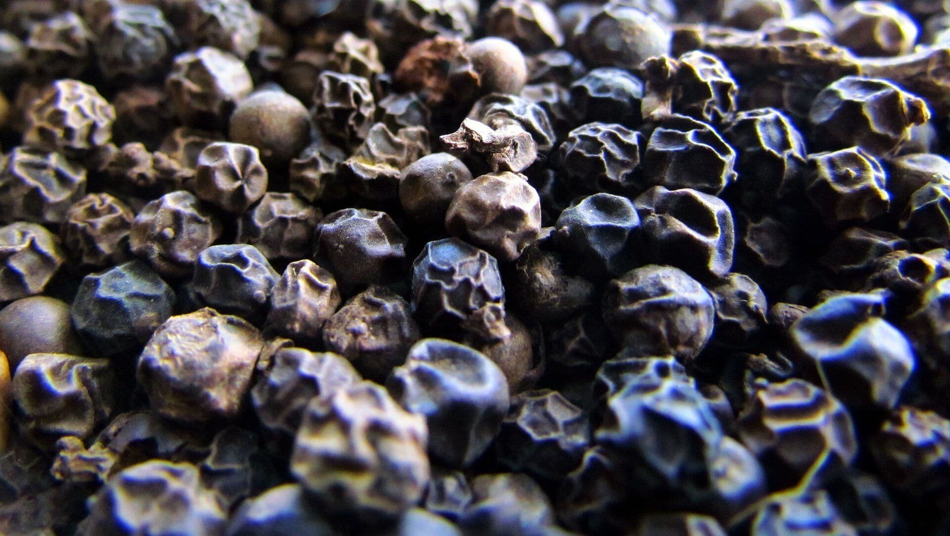 Close-up of whole dried black peppercorns
