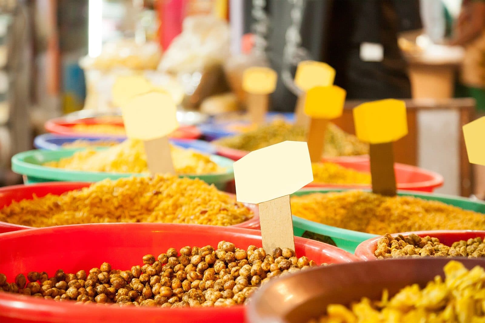 Bowls of colourful Indian namkeen snacks displayed at a market stall