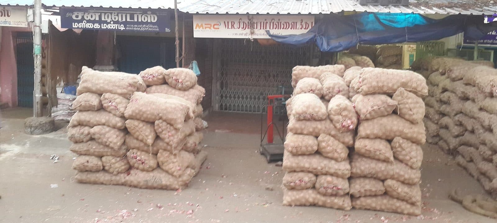Stacks of onion sacks outside a wholesale onion mandi in Tamil Nadu