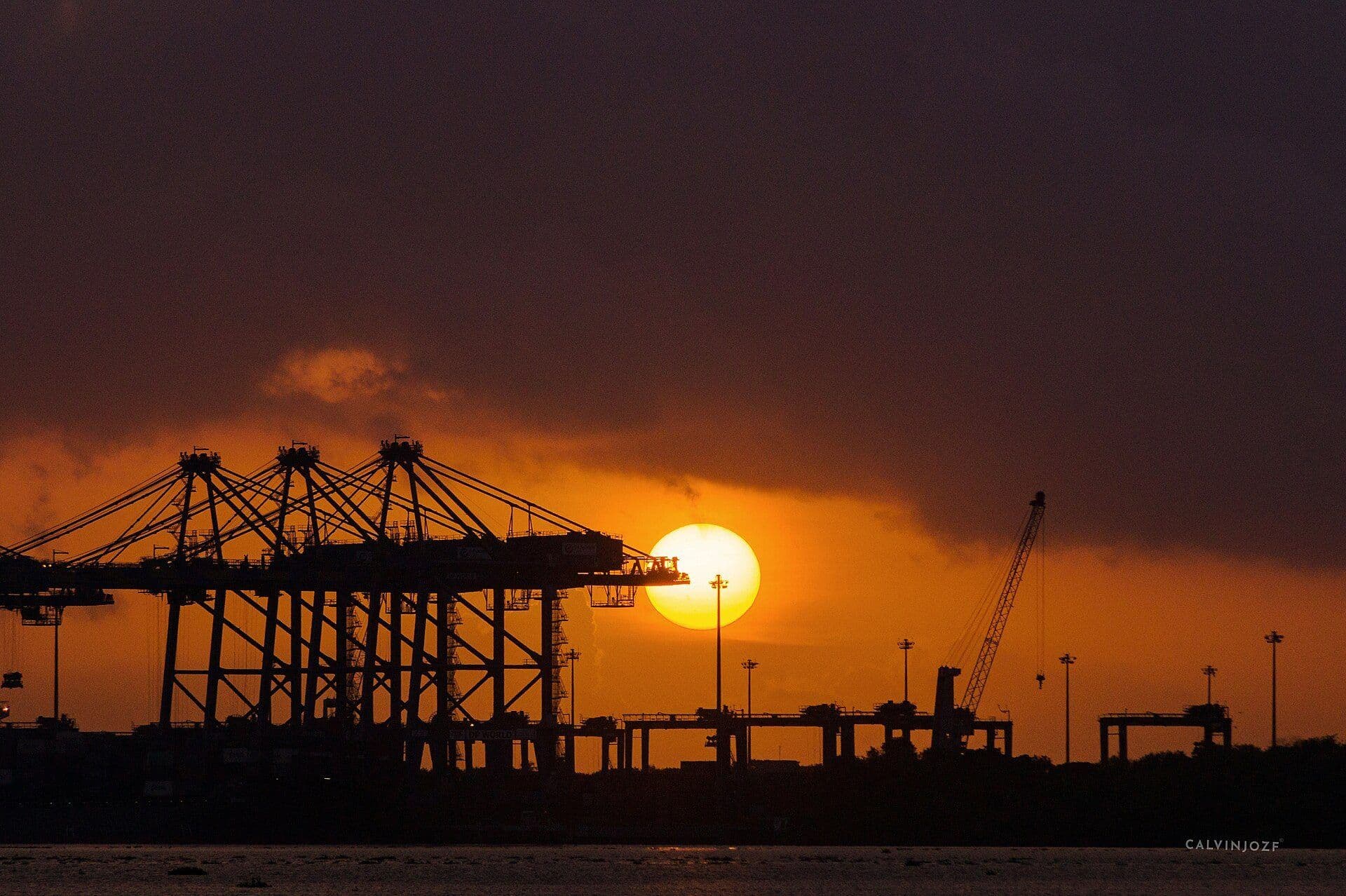 Gantry cranes silhouetted at sunset over the Vallarpadam container terminal in Kochi